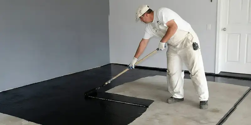 basement waterproofing professional applying waterproof coating to protect a basement floor in Wilmington, NC